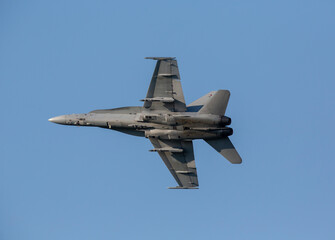 Naklejka na ściany i meble Warfare concept image. Modern jet fighter doing manuevers on a sunny day.