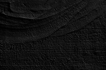 An old grunge background with a black wall texture. Black paint on the wall . Abstract background.Rough brush strokes with black paint.