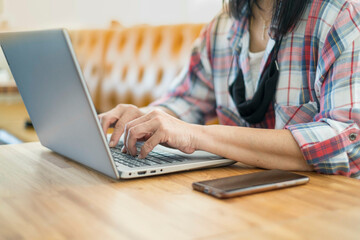 Woman business lifestyle working laptop office modern. shopping online for payment in notebook. female writer keyboarding happy cheerful pleased. girl freelance working at a coffee shop. out of focus