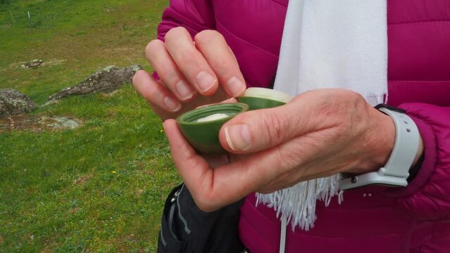 Hands of woman open vaseline container for cracked lips, close up view