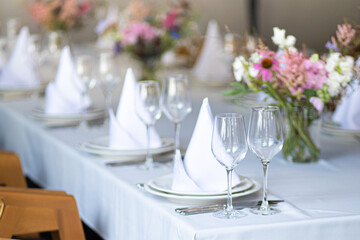 An example of setting tables for a wedding. Wedding decorations. Setting the table for the celebration. Flowers on the table. Preparation for the wedding.
