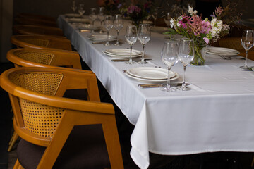 An example of setting tables for a wedding. Wedding decorations. Setting the table for the celebration. Flowers on the table. Preparation for the wedding.