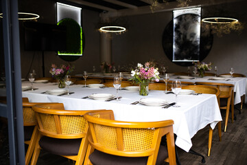 An example of setting tables for a wedding. Wedding decorations. Setting the table for the celebration. Flowers on the table. Preparation for the wedding.