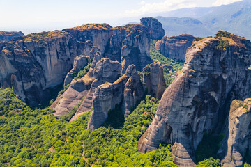 Rock pillars and forest near the town of Kalambaka. Aerial drone perspective. Sunshine. Meteora, Kalambaka in Greece. High quality photo