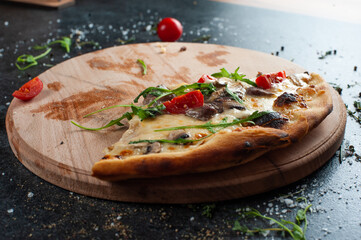 Hot pizza slice with melting cheese on a rustic wooden table.