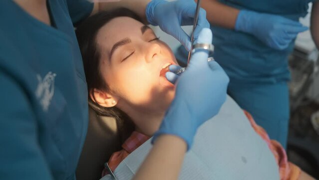 Female dentist with cartridge syringe injecting anesthetic medicine before teeth treatment