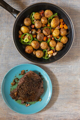 Large fried piece of ham meat in a pan with vegetables and spices, American lunch fried piece of meat and potatoes, beans in sauce and snacks, copy space for text