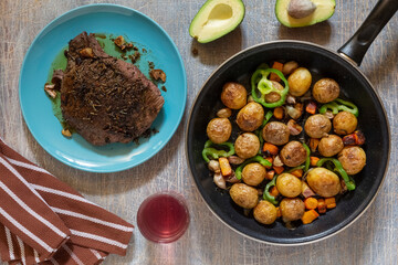 Large fried piece of ham meat in a pan with vegetables and spices, American lunch fried piece of meat and potatoes, beans in sauce and snacks, copy space for text