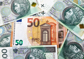 The background consists of hundred zloty notes and 50 euro notes. Currency of Poland