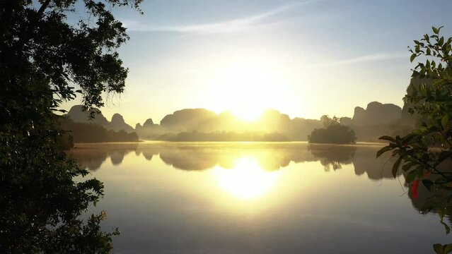 Drone flying from the forest through Nong Thale lake&nbsp;with Limestone mountains at sunrise with motion mist, Krabi, Thailand. Famous travel destination in south of Siam or Thailand.