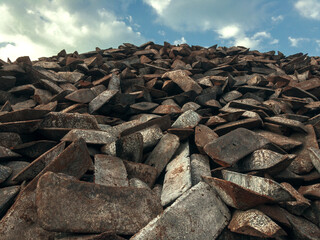 Cast iron ingots in a warehouse against a blue sky. The form of cast iron: ingots, ingots solid condition. Transfer cast iron is cast iron used for further processing into steel.