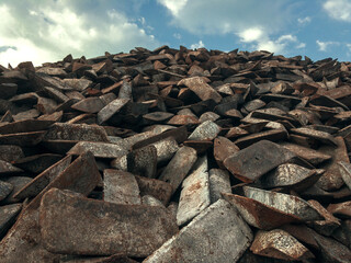 Cast iron ingots in a warehouse against a blue sky. The form of cast iron: ingots, ingots solid...