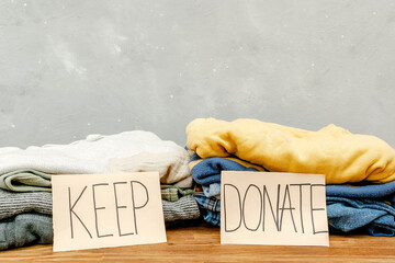 Stack of old baby children clothes sorted into Keep and Donate categories.Donation,volunteering...