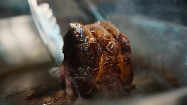 Close-up of a filet mignon being cooked in a frying pan