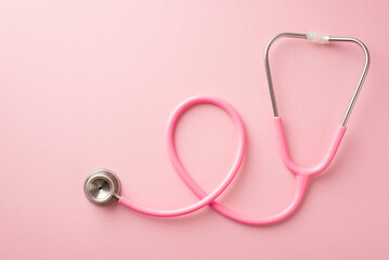 Breast cancer awareness concept. Top view photo of pink stethoscope on isolated pastel pink...