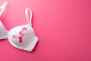 Breast cancer awareness concept. Top view photo of pink ribbon attached to white brassiere on...