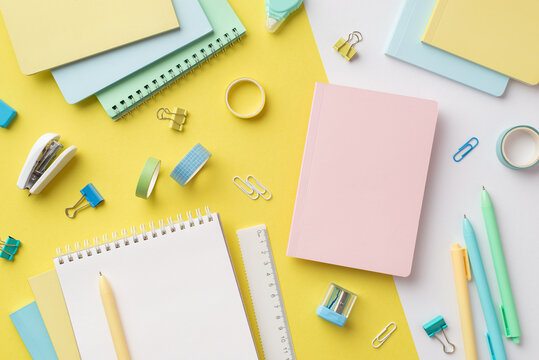 School supplies concept. Top view photo of colorful stationery planners sharpener ruler pens binder clips adhesive tape and mini stapler on bicolor yellow and white background