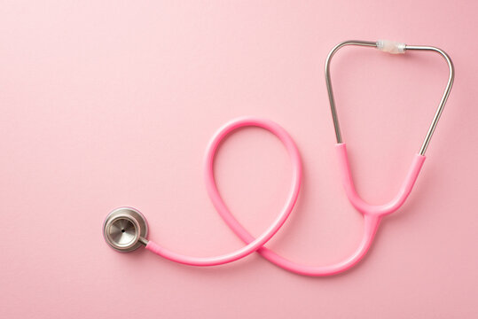 Breast cancer awareness concept. Top view photo of pink stethoscope on isolated pastel pink background