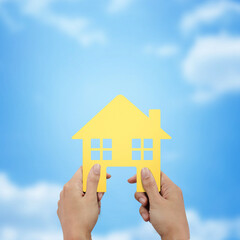 Fototapeta na wymiar Hand holding house shape at blue sky background.