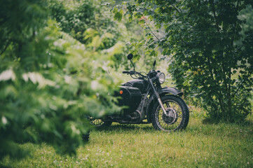 black retro motorcycle with sidecar in nature