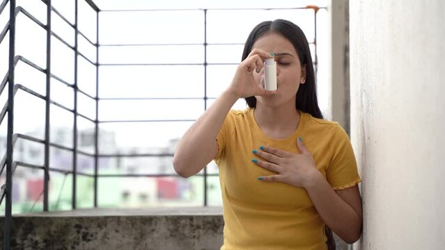 Asthmatic patient catching inhaler having an asthma attack. Young woman having asthma, chronic obstructive pulmonary disease