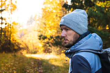 Portrait of man in autumn forest during hiking trip. Travel concept, hike, fall season. Closeup, copy space