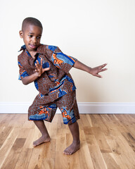 Traditional Ghanaian Fashion. Bright Kente fabrics from Ghana, West Africa, being modelled by carefree young Ghanaian children. Part of a series.