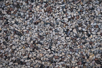 Mixed small gray broken rocks, loose gravel, road construction. Limestone aggregate. Crushed stone background