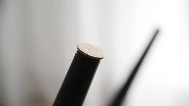 A man glues protective pads on the legs of a chair. Protection against floor scratches and noise, close-up
