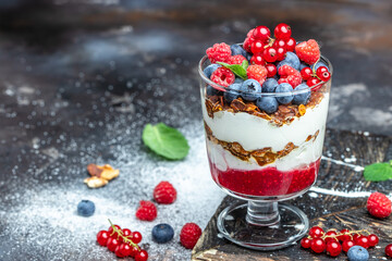 Layered dessert with berry in a jar. yogurt granola parfait with blueberry and raspberry