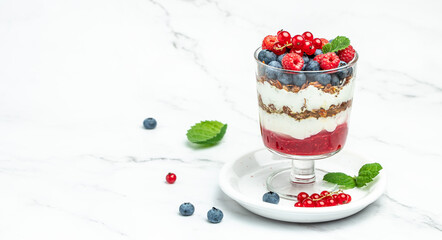 yogurt granola parfait with blueberry and raspberry on a light background. Long banner format