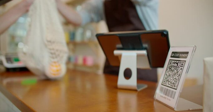 Customer using smartphone scanning shop QR code for contactless paying at zero waste plastic free grocery store. Cashless payment lifestyle. Small business go green startup for reduce climate change.