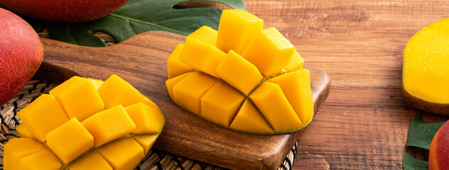 Mango. Fresh mango fruit with leaves over dark wooden table background.
