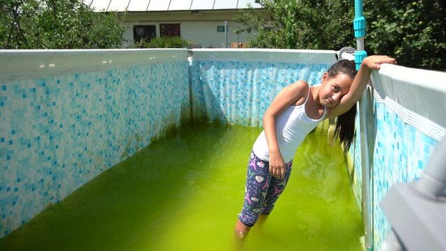 a little girl cleans a very dirty pool