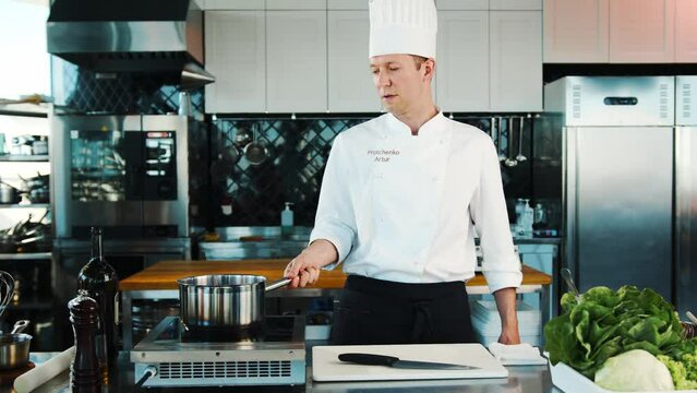 The chef sets fire to the dish in the professional kitchen of the restaurant. The process of cooking food with fire.