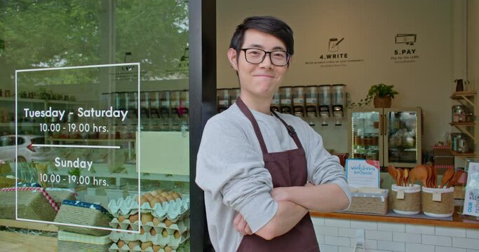 Portrait of happy asian man eco friendly shop owner smiling, looking at camera on plastic free grocery store background. Sustainable small local business startup go green market. Reduce Reuse Recycle.