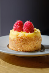 mignon with cream and raspberries. Mini raspberry cheesecake on a plate in a cafe.