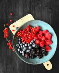 strawberries and blueberries, blackberries and red currant in a bowl