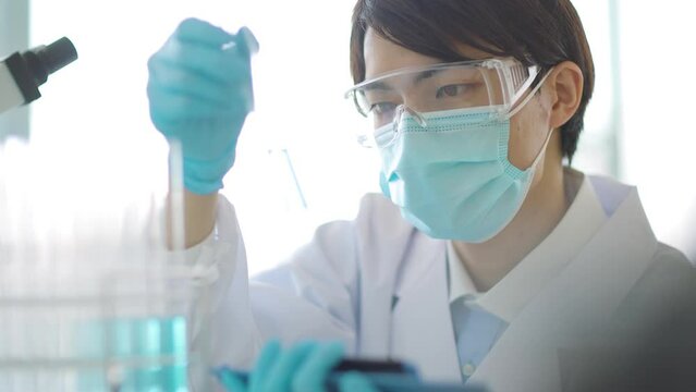 試験管を観察する研究者 