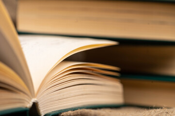 A stack of books and an open book on the table. Close-up, selective focus