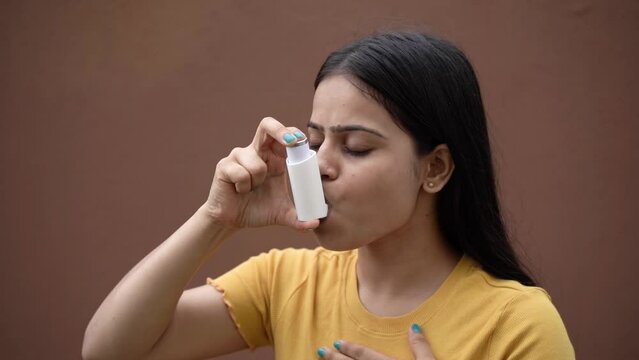 Asthmatic patient catching inhaler having an asthma attack. Young woman having asthma, chronic obstructive pulmonary disease