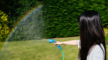 Woman watering the plants and rainbow appearing