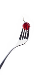 Obraz premium gooseberries on a fork on a white background