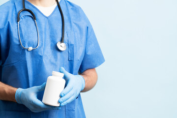 Close up picture of male doctor with stethoskope over neck showing a bottle of pills. No label bottle for product placement.