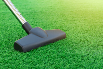 Selective focus of a vacuum cleaner on a sheet of artificial turf. Lawn care and maintenance. Easy...