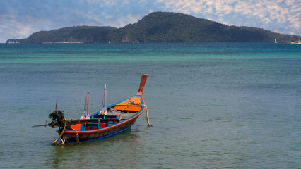 Colourful Skies Sunset over Rawai Beach in Phuket island Thailand. Lovely turquoise blue waters, lush green mountains colourful skies and beautiful views of Pa Tong Patong