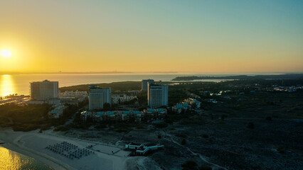 Aerial Bird's eye view of huge sunrise over Troia Peninsula on a sunny day, near Lisbon.