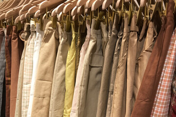 Multicolored skirts in the same tone are hung on a wooden hanger.
