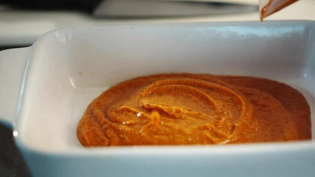 Professional restaurant kitchen, close-up: the sauce is applied to a baking sheet