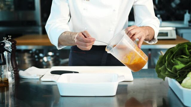 Professional restaurant kitchen, close-up: The chef creates sauce for meat